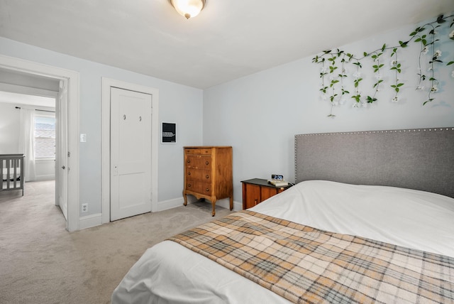 bedroom with baseboards and light carpet