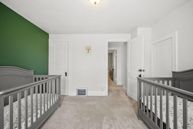 carpeted bedroom with visible vents and baseboards