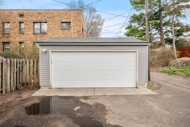 detached garage featuring fence