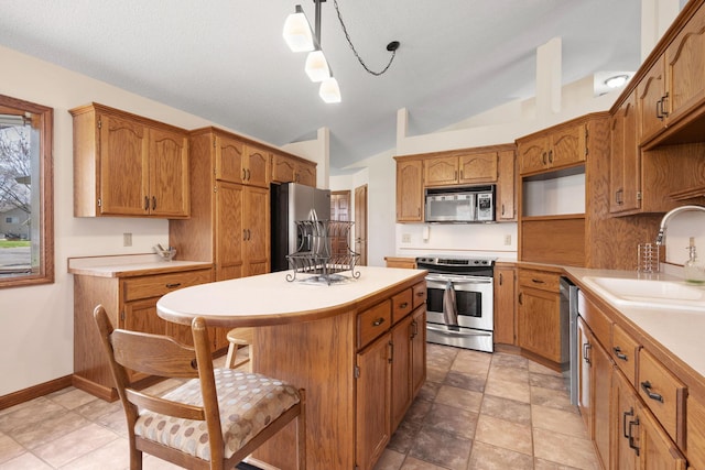 612 19th St N, Sartell, MN 56377 - kitchen featuring appliances with stainless steel finishes, a kitchen island, brown cabinets, a sink, and lofted ceiling