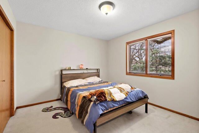 612 19th St N, Sartell, MN 56377 - carpeted bedroom featuring a textured ceiling, a closet, and baseboards