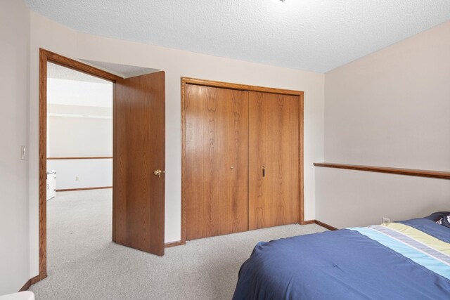 612 19th St N, Sartell, MN 56377 - carpeted bedroom with a closet, a textured ceiling, and baseboards