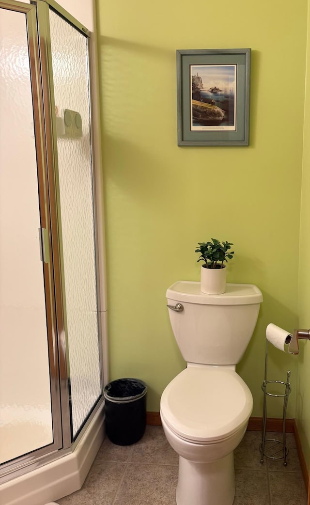 bathroom featuring tile patterned floors, baseboards, and a stall shower