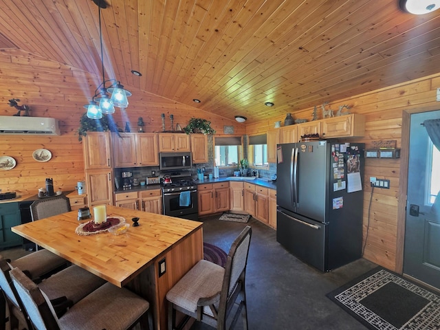 49818 Long Lake Trl, Bigfork, MN 56628 - kitchen with freestanding refrigerator, gas stove, stainless steel microwave, vaulted ceiling, and finished concrete floors