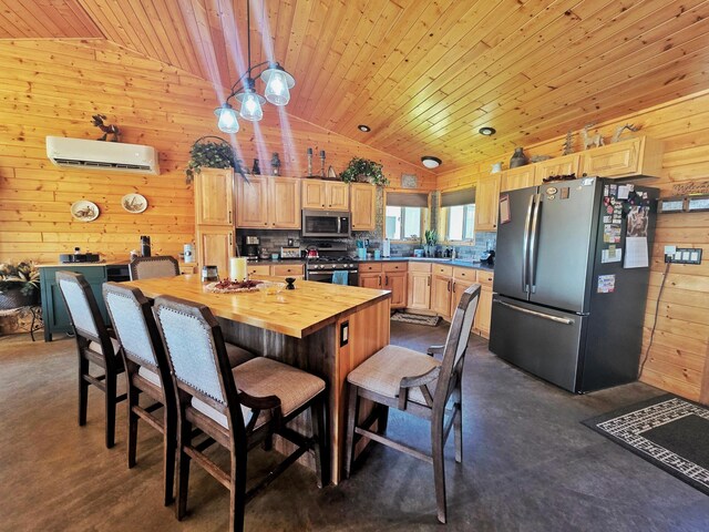 49818 Long Lake Trl, Bigfork, MN 56628 - kitchen featuring appliances with stainless steel finishes, vaulted ceiling, an AC wall unit, butcher block counters, and light brown cabinetry