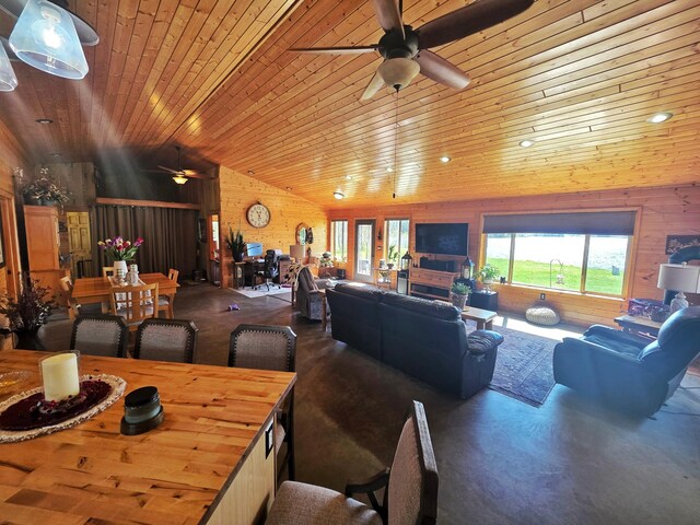 49818 Long Lake Trl, Bigfork, MN 56628 - living area featuring ceiling fan, wooden ceiling, vaulted ceiling, wood walls, and concrete floors
