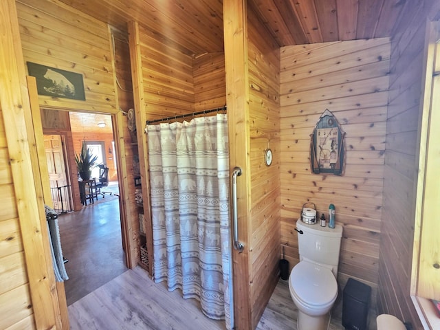 49818 Long Lake Trl, Bigfork, MN 56628 - bathroom with wood walls, toilet, wood finished floors, wood ceiling, and a shower with curtain