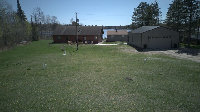 49818 Long Lake Trl, Bigfork, MN 56628 - view of green lawn with a garage, dirt driveway, and an outbuilding
