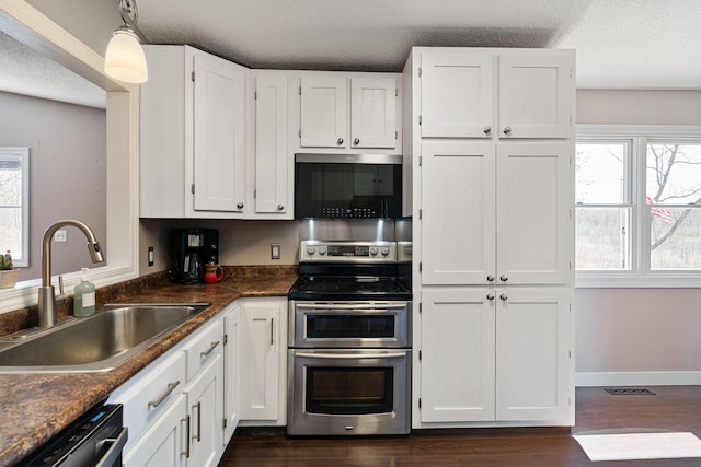 695 Pine Lake Ln, Bone Lake Twp, WI 54837 - kitchen featuring a textured ceiling, a sink, dark countertops, white cabinets, and appliances with stainless steel finishes