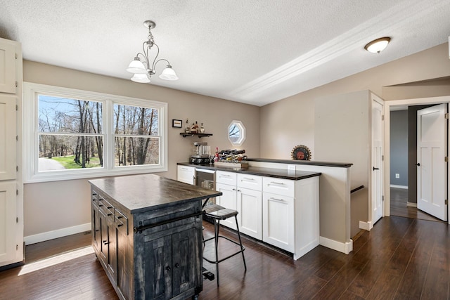 695 Pine Lake Ln, Bone Lake Twp, WI 54837 - kitchen featuring a textured ceiling, dark wood-style floors, white cabinets, baseboards, and dark countertops