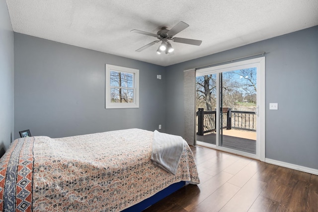 695 Pine Lake Ln, Bone Lake Twp, WI 54837 - bedroom featuring baseboards, access to outside, a textured ceiling, and wood finished floors