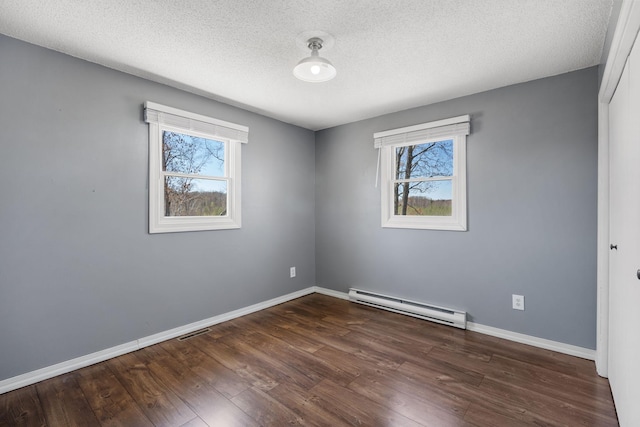 695 Pine Lake Ln, Bone Lake Twp, WI 54837 - unfurnished room with visible vents, dark wood-style flooring, a baseboard radiator, and a healthy amount of sunlight