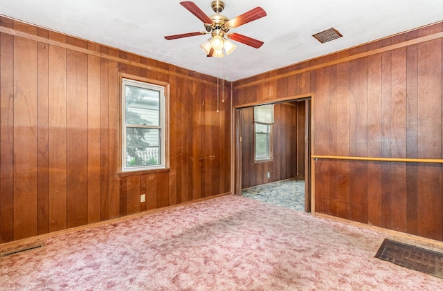 316 Main St, Belle Plaine, MN 56011 - carpeted empty room featuring wood walls and a ceiling fan