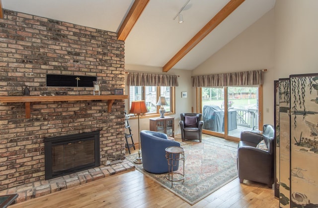 living room with high vaulted ceiling, hardwood / wood-style floors, a fireplace, and beamed ceiling