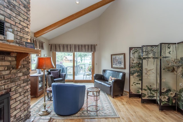 living area with high vaulted ceiling, a fireplace, light wood-style flooring, and beam ceiling