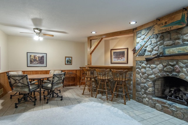 dining space featuring wainscoting, ceiling fan, and light tile patterned floors