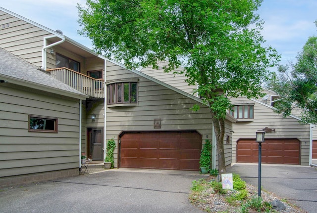townhome / multi-family property with a balcony and driveway