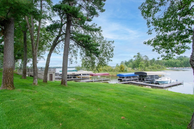 view of yard with a water view and a dock