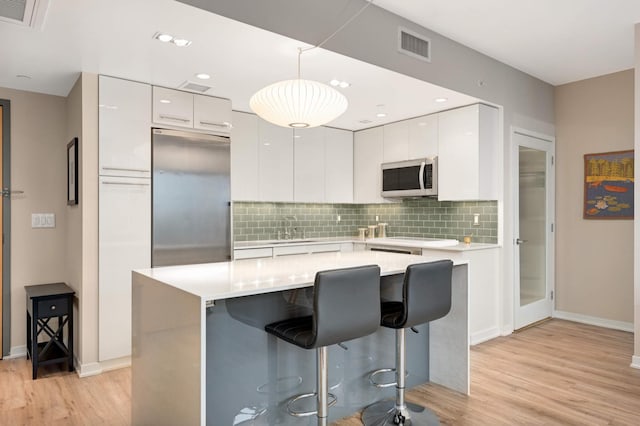 kitchen with a sink, appliances with stainless steel finishes, modern cabinets, and white cabinets