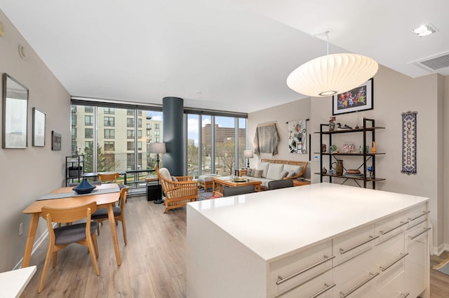 kitchen featuring visible vents, light countertops, light wood finished floors, and a kitchen island