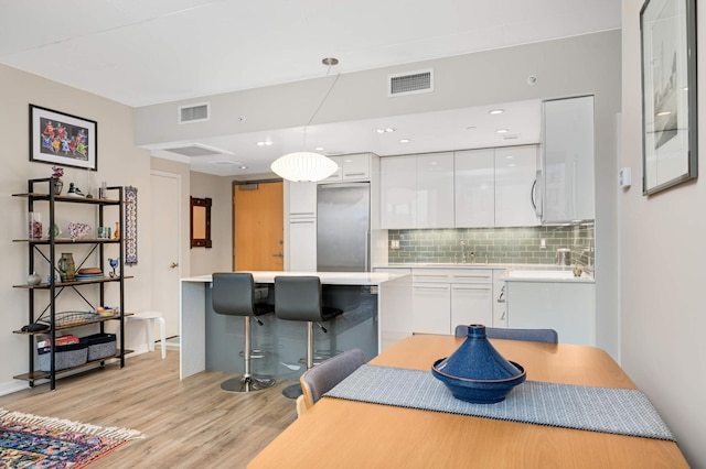 dining room featuring visible vents and light wood-style flooring