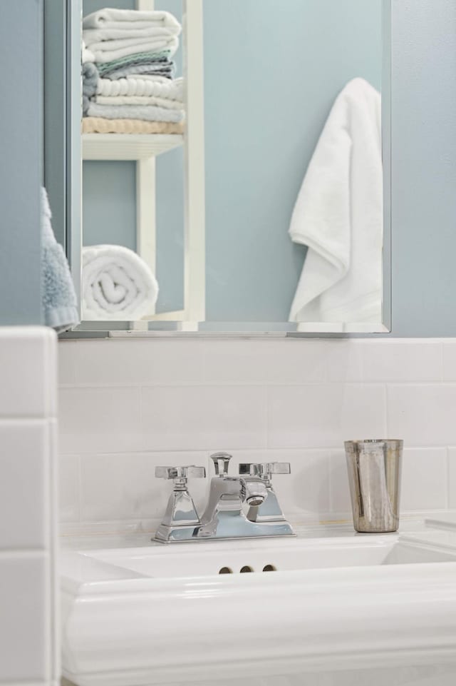 bathroom featuring a sink and tasteful backsplash