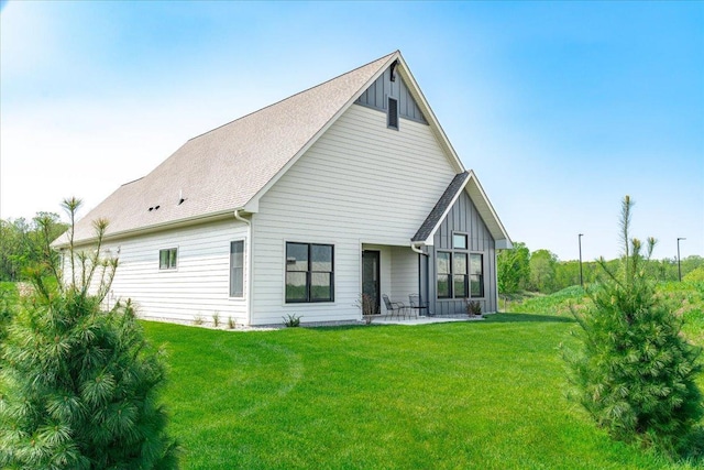 2229 Sharon Ln, Hudson, WI 54016 - back of property featuring board and batten siding, a yard, and a patio area