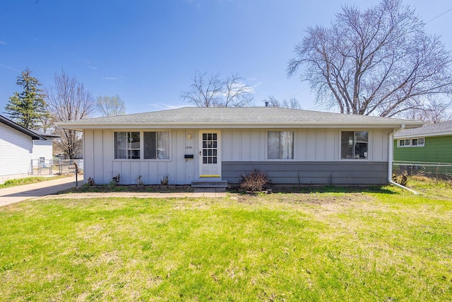 ranch-style home with fence, board and batten siding, entry steps, and a front yard