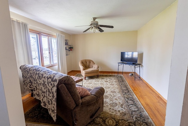 living room featuring a ceiling fan and wood finished floors