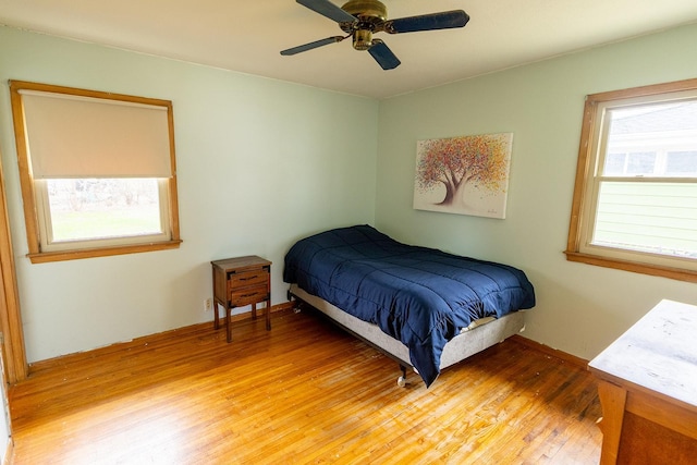 bedroom featuring light wood-style flooring, ceiling fan, and multiple windows