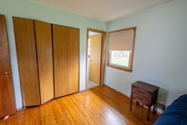 unfurnished bedroom featuring a closet and light wood finished floors