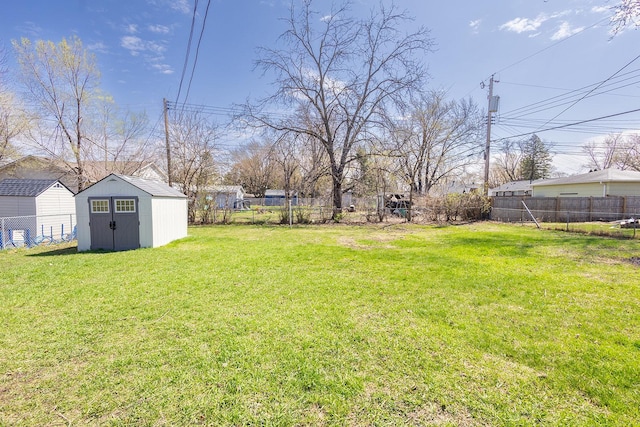 view of yard with a storage unit, a fenced backyard, and an outdoor structure