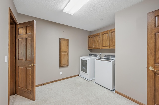 1427 Rosewood Ct, New Brighton, MN 55112 - laundry area featuring washing machine and dryer, cabinet space, light carpet, a textured ceiling, and baseboards