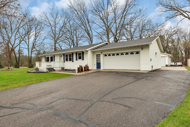 ranch-style home with a porch, a shingled roof, an attached garage, and a front yard