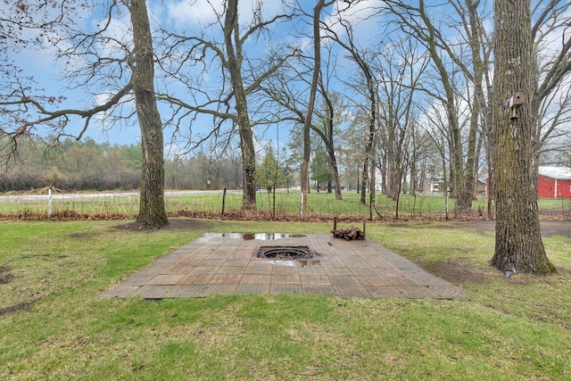 view of yard with an outdoor fire pit, a patio area, and fence