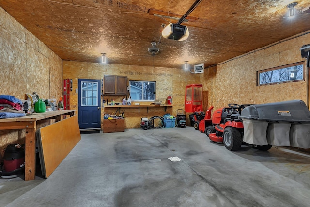 garage with a workshop area and a garage door opener