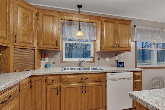 kitchen featuring light countertops, white dishwasher, and a sink