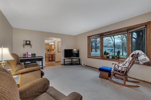 living room with carpet floors, baseboards, and a notable chandelier