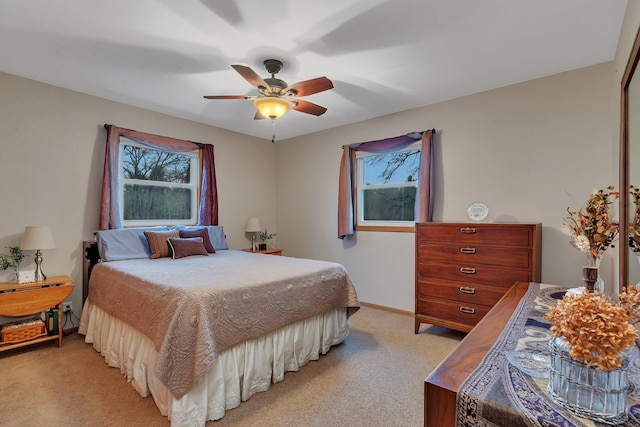 bedroom featuring baseboards, ceiling fan, and light carpet