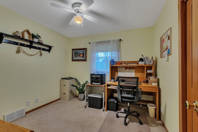 carpeted home office featuring visible vents, baseboards, and ceiling fan