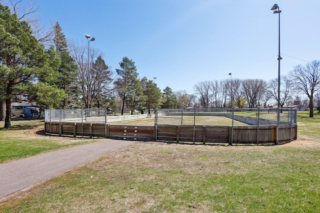 view of home's community with a lawn, a gate, and fence