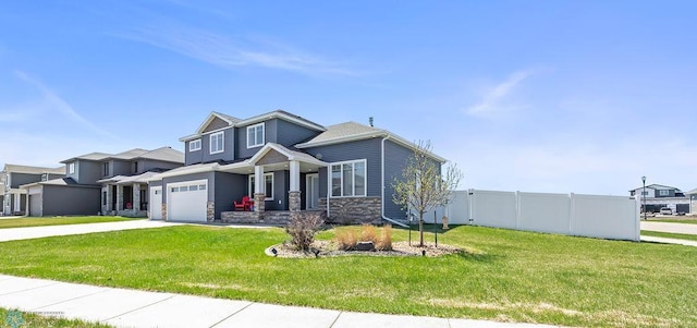 craftsman house with stone siding, driveway, fence, and a front yard