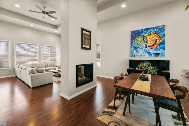 dining area with hardwood / wood-style floors, recessed lighting, ceiling fan, baseboards, and a glass covered fireplace