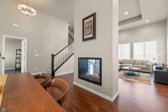 office area with baseboards, a glass covered fireplace, recessed lighting, and dark wood-type flooring