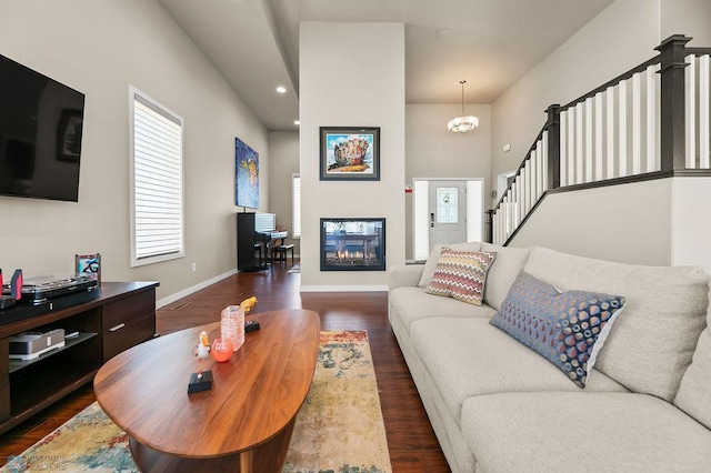 living room featuring baseboards, stairs, dark wood finished floors, and recessed lighting