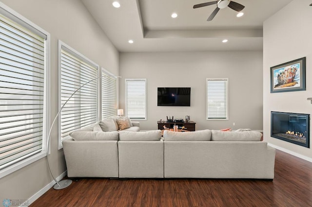 living room with recessed lighting, baseboards, dark wood-style flooring, a glass covered fireplace, and ceiling fan