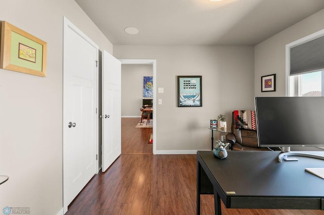 office space with baseboards and dark wood-style floors
