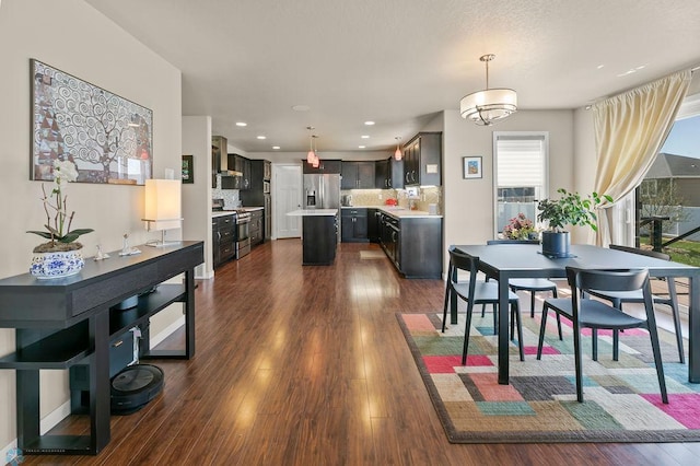 dining room with dark wood finished floors and recessed lighting