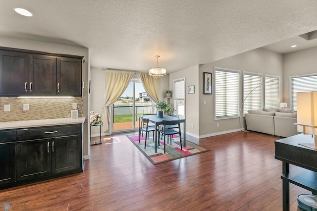 dining room featuring baseboards, dark wood-style flooring, and a healthy amount of sunlight