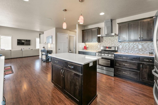 kitchen with wall chimney range hood, dark wood-style flooring, gas stove, backsplash, and open floor plan
